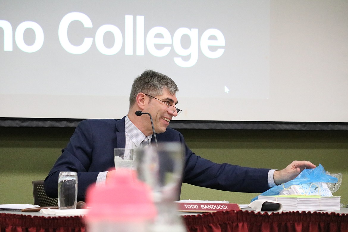 North Idaho College board of trustees chair Todd Banducci reaches for the stack of papers in his support, and 1,000 index cards asking for him to resign at the board meeting on Wednesday night at the college campus in Coeur d'Alene. HANNAH NEFF/Press