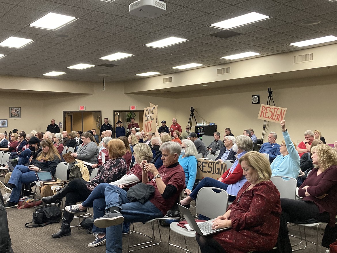 Community members held signs asking for Todd Banducci, board chair of the North Idaho College board of trustees, to resign at the board meeting on Wednesday at the college campus in Coeur d'Alene. HANNAH NEFF/Press