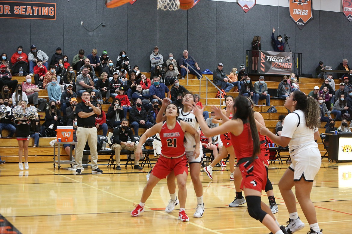 Othello High School player Persayis Garza (21) boxes out in a Dec. 17 game against Ephrata while head coach Adolfo Coronado (back, black shirt) watches.