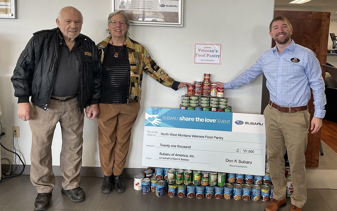 Kevin Kaltschmidt, general manager of Don “K” Subaru,, presents a check for $21,000 and 355 pounds of food to Allen and Linda Erickson, founders of the North West Montana Veterans Pantry.