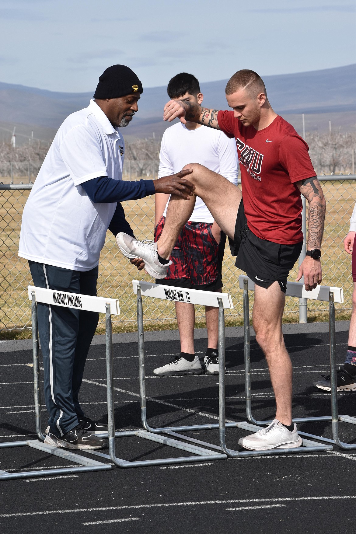 Olympic gold medalist Andre Phillips shows a Central Washington University athlete the proper form for going over a hurdle at the track and field camp on March 26.