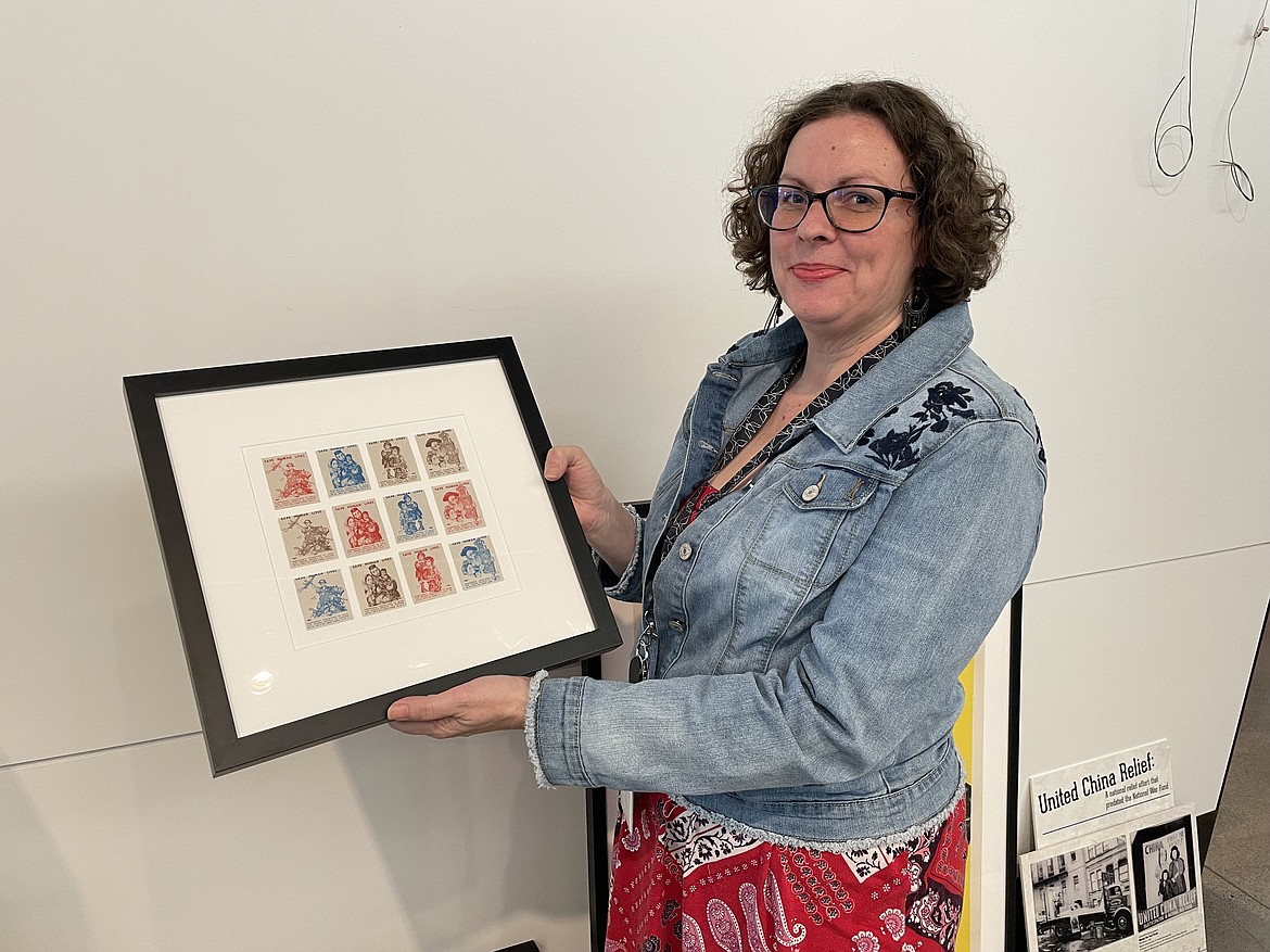 Moses Lake Museum and Art Center Manager Dollie Boyd holds up a sheet of Cinderella stamps designed to raise relief money for China during WWII. The stamps are on display at the museum through April, 29 as part of “Work, Fight, Give,” an exhibit of WWII aid and relief posters.