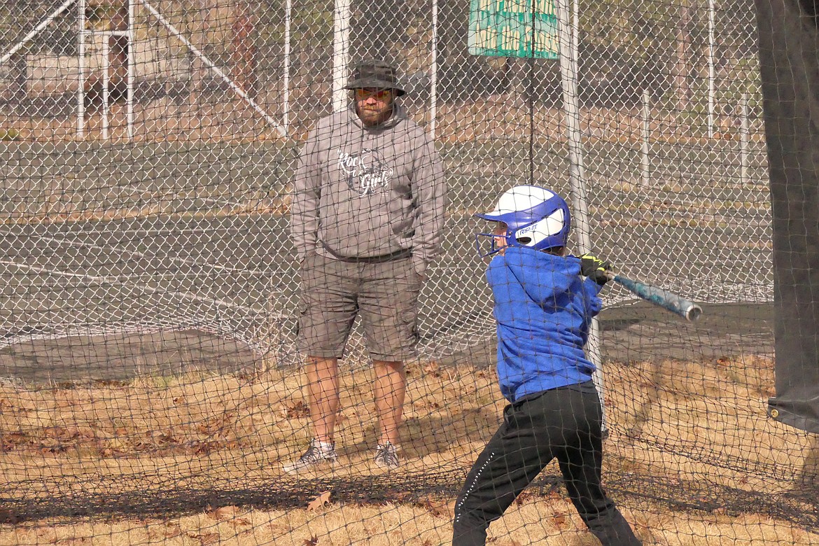 T-Falls softball coach Jared Koskela watches as McKenzie Robinson takes swings in the batting cage during preseason practice last week in T Falls.