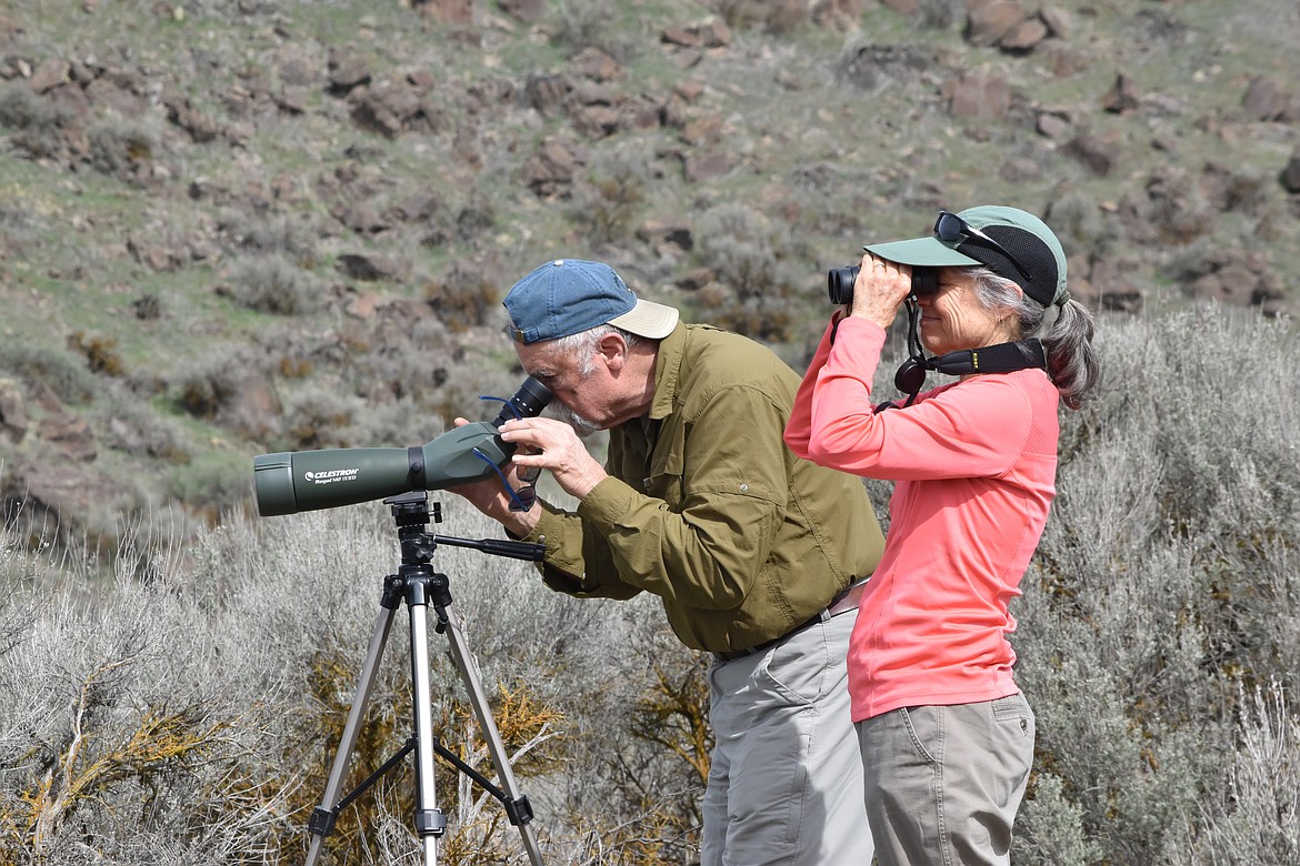 Jay (left) and Janice (right) Berube of Kettle Falls look at the wildlife of Marsh Unit 1 through binoculars and a spotting scope on March 26 during the Othello Sandhill Crane Festival.