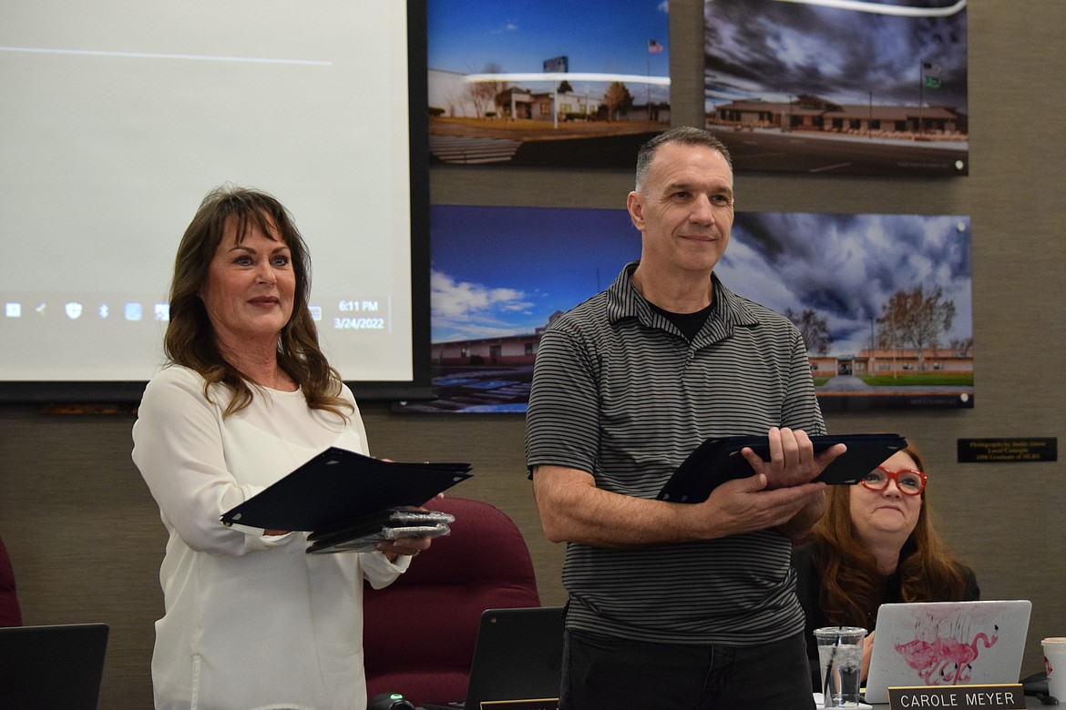 Moses Lake School Board members Shannon Hintz (left) and Kevin Fuhr (right) hand out certificates of appreciation to faculty and staff at a regular school board meeting last Thursday.