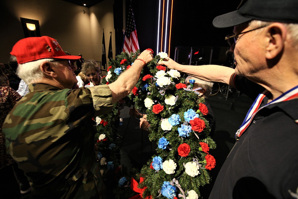 Vietnam War veterans David Morgensen, right, and Kenny Moore place carnations on a wreath during Tuesday's "Soldiers of Vietnam - Welcome Home" celebration.