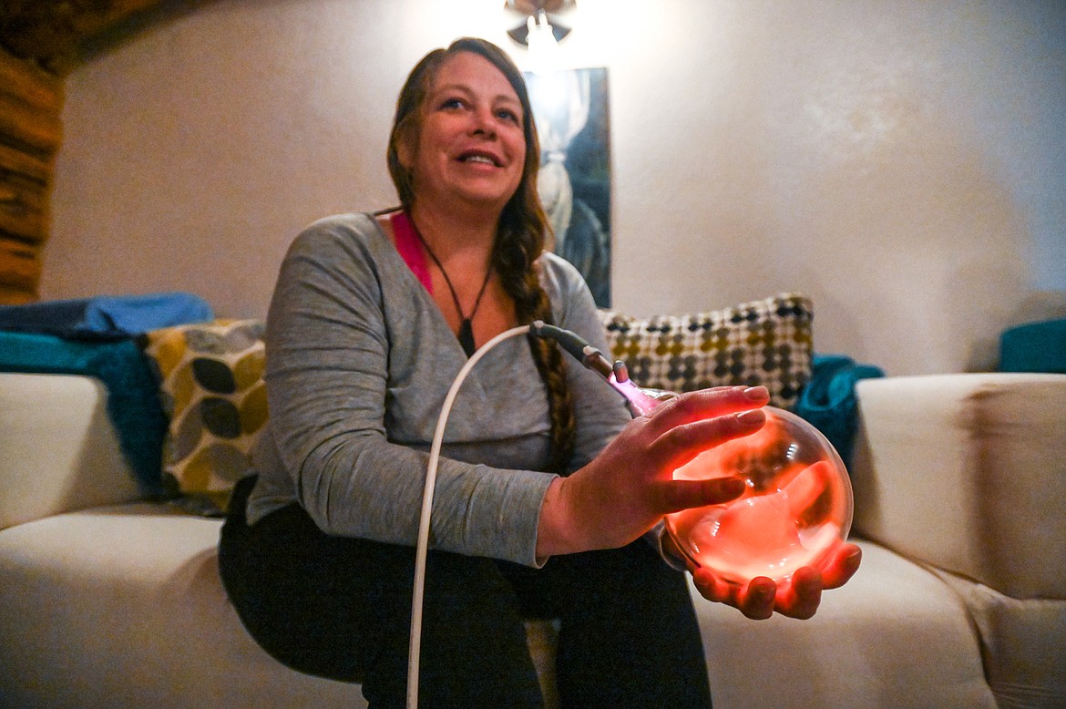 Rebecca Couture demonstrates using the bulb of a molecular enhancer at Zen Den in Eureka on Wednesday, March 30. (Casey Kreider/Daily Inter Lake)