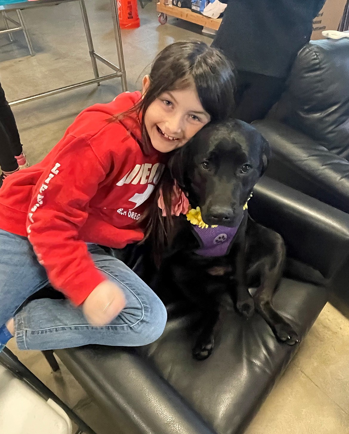 Sadie Bean, a therapy dog at Wired2Learn Academy, cuddles with student Aubrey Eirls.