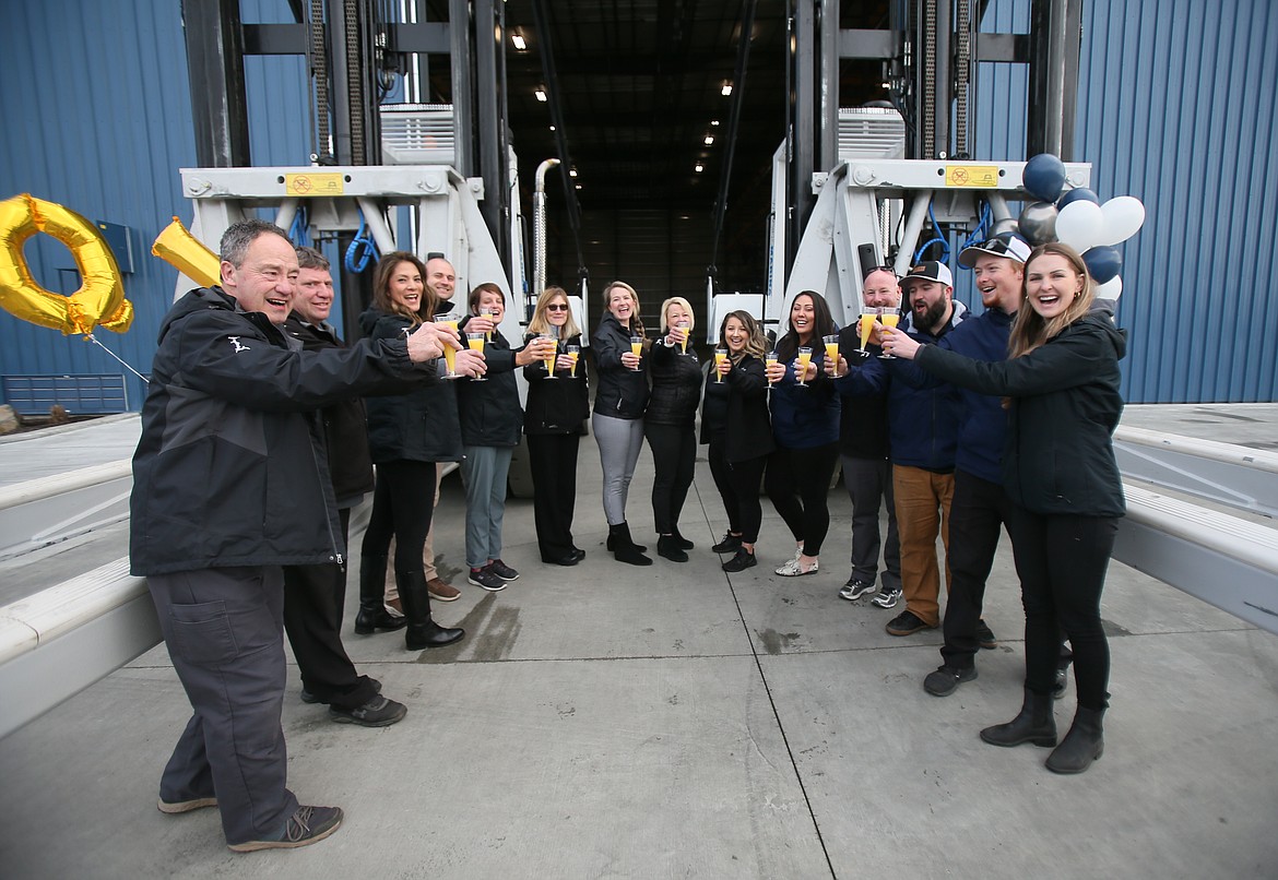 Hagadone Marine Group team members say "Cheers!" as they celebrate the opening of the Vertical Quick Launch facility Friday morning. From left: Jim Brown, Carl Fus, Melissa Menke, Chris Jenkins, Sarah Tooker, Amy Kobrick, Lindsey Olmstead, Monica Rozier, Molly Mulholland, Nicole Baker, AJ Haynes, Cameron Lounsbury, Steven Orser and Cally King.