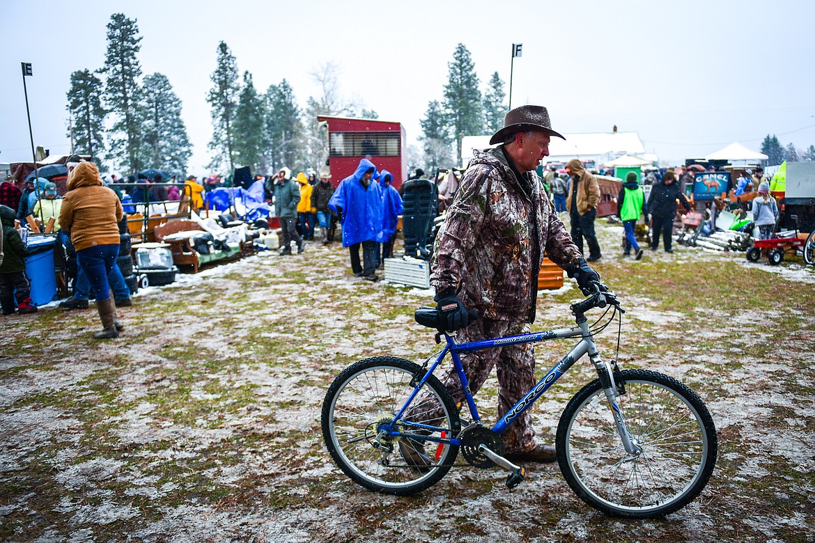 Chris Allen pushes a bicycle he won during a sale at the 56th annual Creston Auction on Saturday, April 2. The Creston Auction and Country Fair is the largest annual fundraiser for the all-volunteer Creston Fire Department and has been held in Creston since 1966. (Casey Kreider/Daily Inter Lake)
