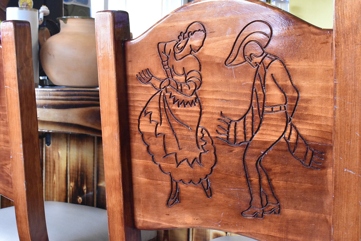 The chairs in the bar at Mi Cocinita Mexican Grill and Cantina have simple carvings of people on the back.