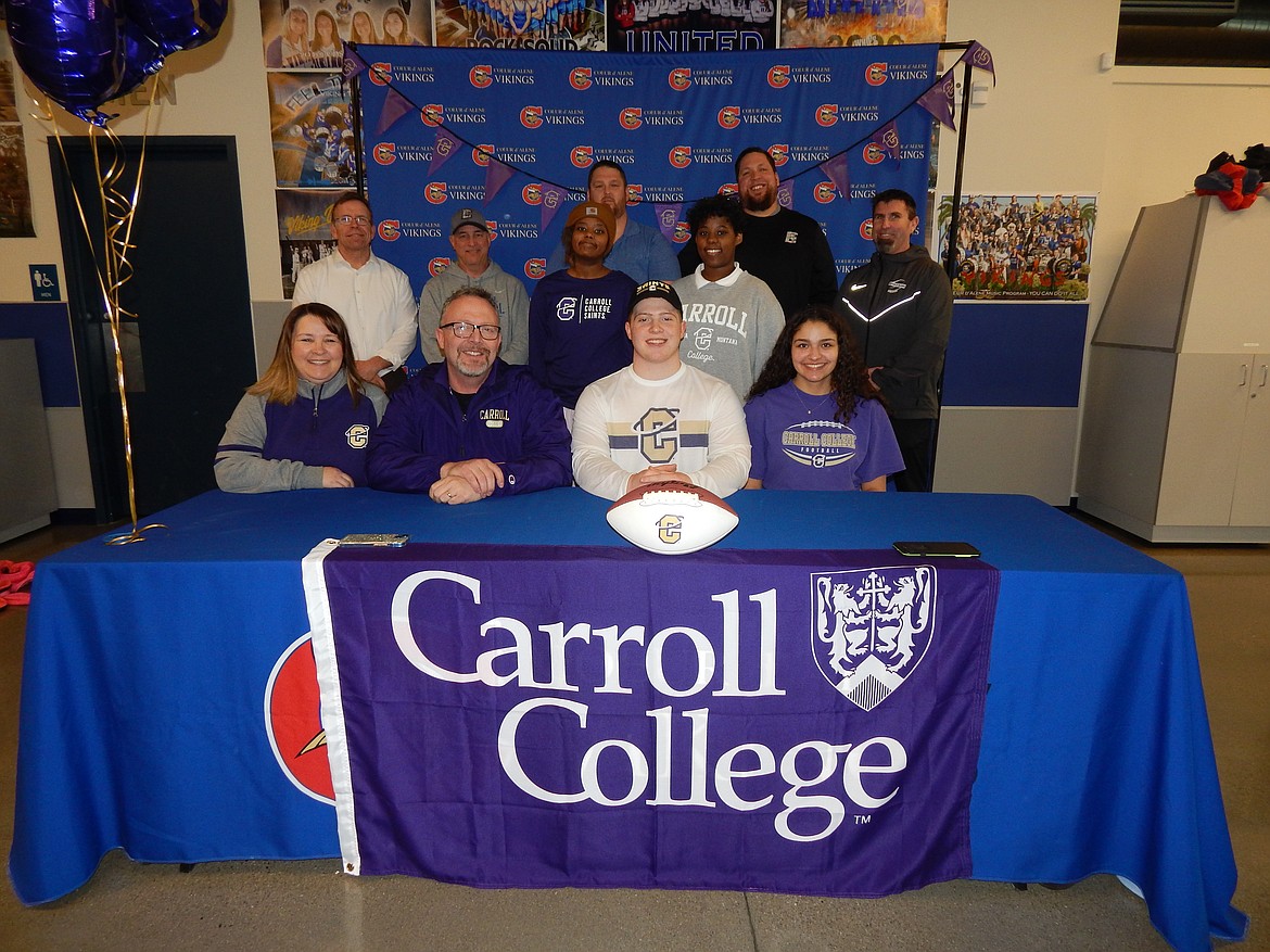 Courtesy photo
Coeur d'Alene High senior Jaxson Washington recently signed a letter of intent to play football at NAIA Carroll College in Helena, Mont. Seated from left are Phebe Washington (mom), Greg Washington (dad), Jaxson Washington and Tiannna (girlfriend); standing front row from left, Mike Randles, Coeur d'Alene High principal; Shawn Amos, Coeur d'Alene High head football coach; and sisters Maara and Mihret; and standing back row from left, Coeur d'Alene High assistant football coaches Corey Brown, Colin Donovan and Dustin Shafer.