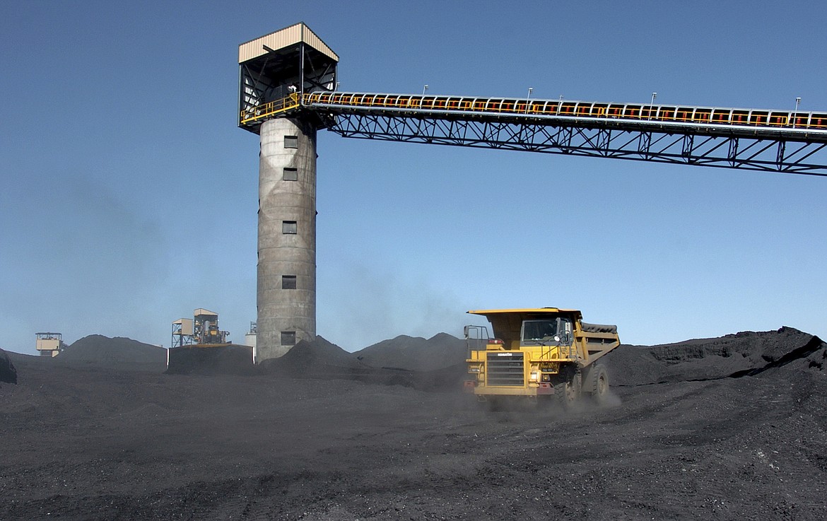 FILE - Heavy equipment moves coal outside Signal Peak Energy's Bull Mountain mine near Roundup, Mont., on Aug. 28, 2009. A federal appeals court says U.S. officials improperly downplayed the climate change impacts from burning coal when they approved a large expansion at an underground Montana mine that would release an estimated 190 million tons of greenhouse gasses into the atmosphere. The 9th U.S. Circuit Court of Appeals said in a ruling Monday, April 4, 2022 that Interior Department officials "hid the ball" under the Trump administration by failing to fully account for emissions from burning the fuel.(AP Photo/Matthew Brown, File)