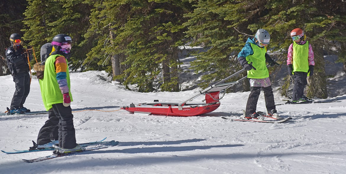 A SheJumps Junior Ski Patrol Day participant drives a toboggan at Whitefish Mountain Resort. (Julie Engler/Whitefish Pilot)