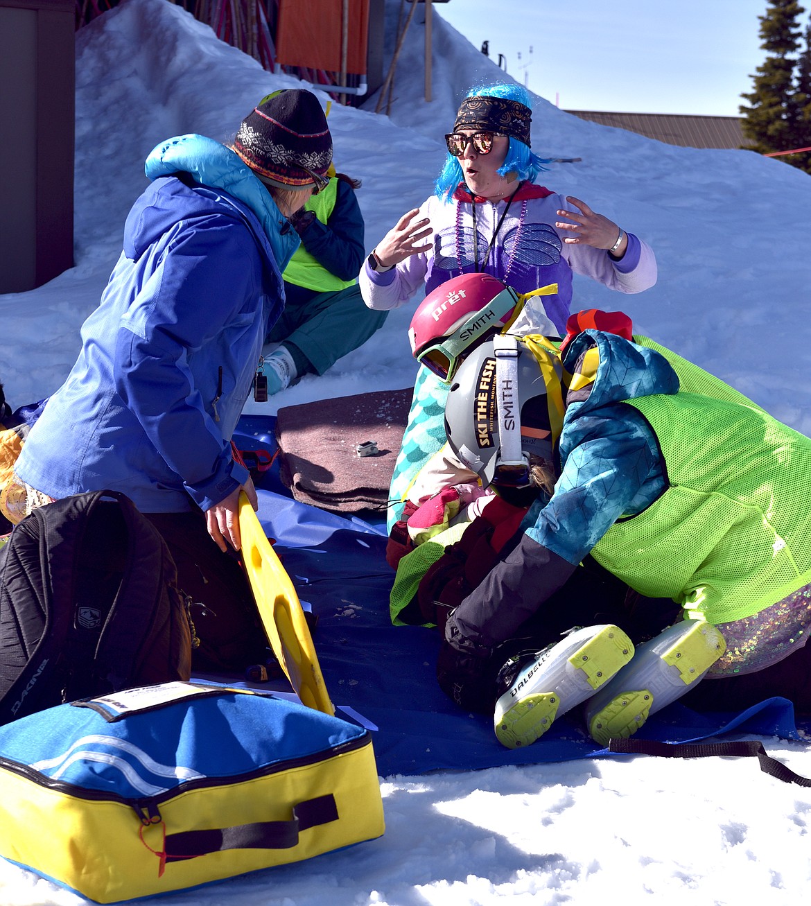 Patrollers help SheJumps Junior Ski Patrol Day participants practice rolling a "patient" onto a backboard. (Julie Engler/Whitefish Pilot)