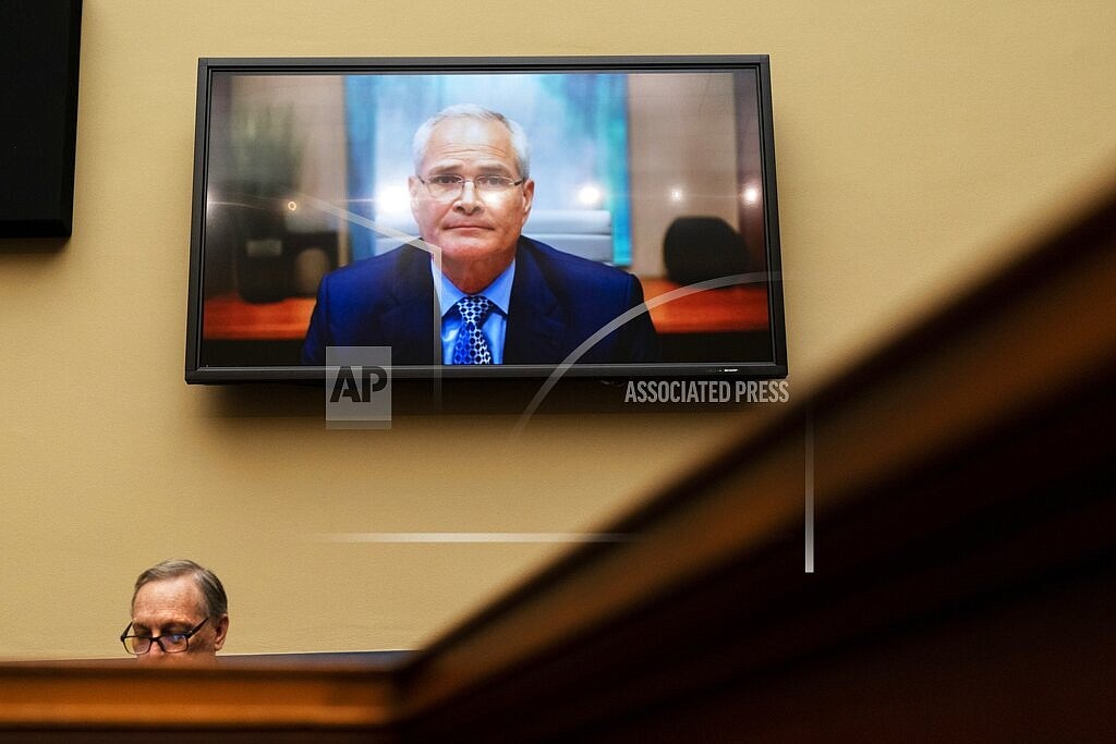 Darren Woods, CEO of ExxonMobil, testifies via video conference during a House Committee on Oversight and Reform hearing on the role of fossil fuel companies in climate change, Oct. 28, 2021, with Rep. Ralph Norman, R-S.C., at left, on Capitol Hill in Washington. House Democrats are accusing oil companies of “ripping off the American people” and putting profits before production as Americans suffer from higher gasoline prices amid the war in Ukraine. Oil executives, testifying before Congress for the second time in six months, responded that oil is a global market and that oil companies don’t dictate prices. (AP Photo/Jacquelyn Martin, File)