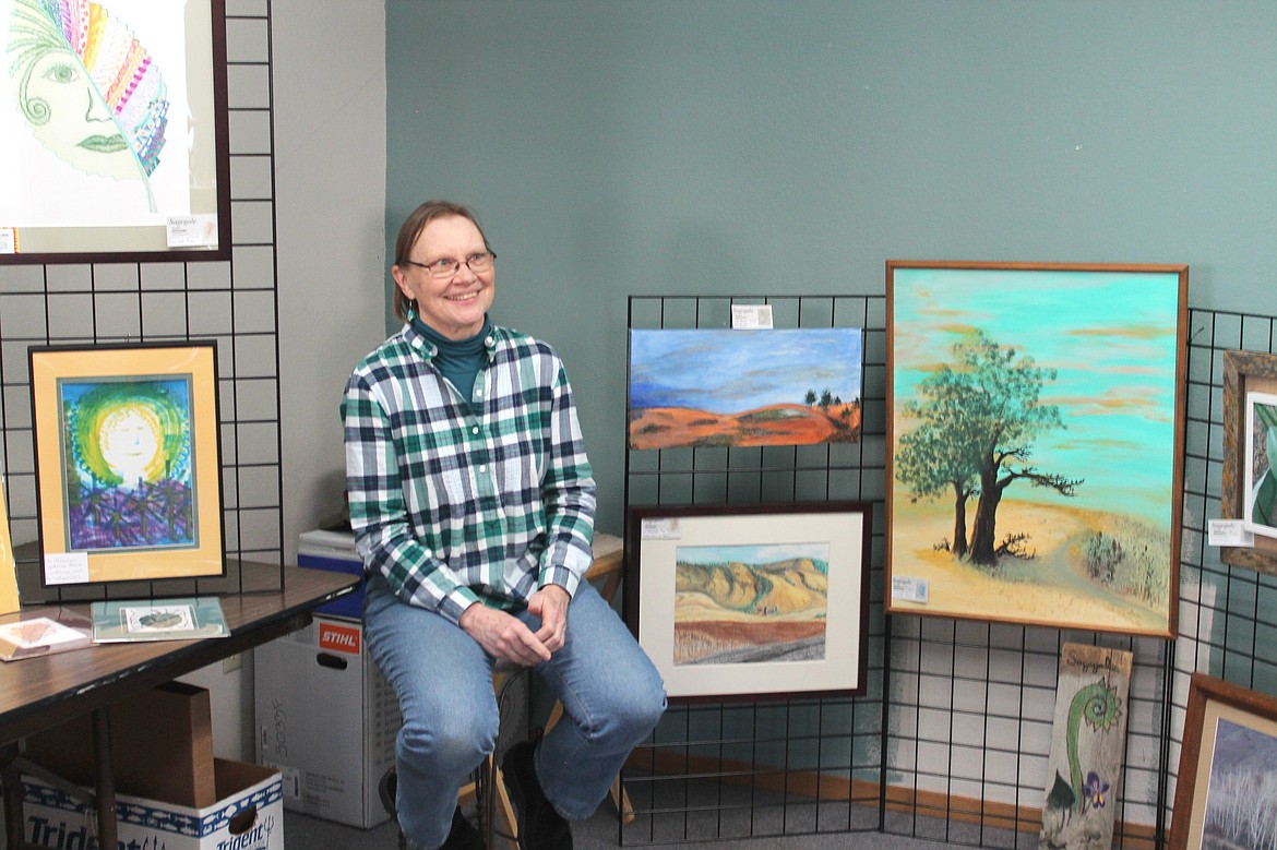 Amy Larsen shows some of her paintings at the April Fools Art Walk in Coulee City April 1. Larsen was one of several artists and authors that participated in the event.