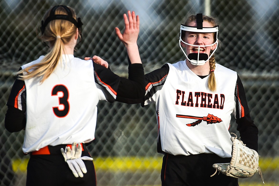 Flathead pitcher Lacie Franklin (22) high-fives third baseman Brynn Mailman (3) after Franklin caught an infield pop-up against Libby at Kidsports Complex on Thursday, April 7. (Casey Kreider/Daily Inter Lake)