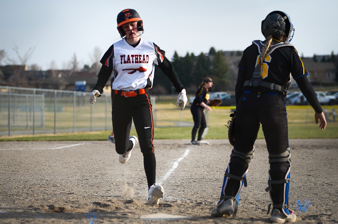 Flathead's Macy Craver (30) scores on a first-inning double by Mackenzie Brandt (8) against Libby at Kidsports Complex on Thursday, April 7. (Casey Kreider/Daily Inter Lake)