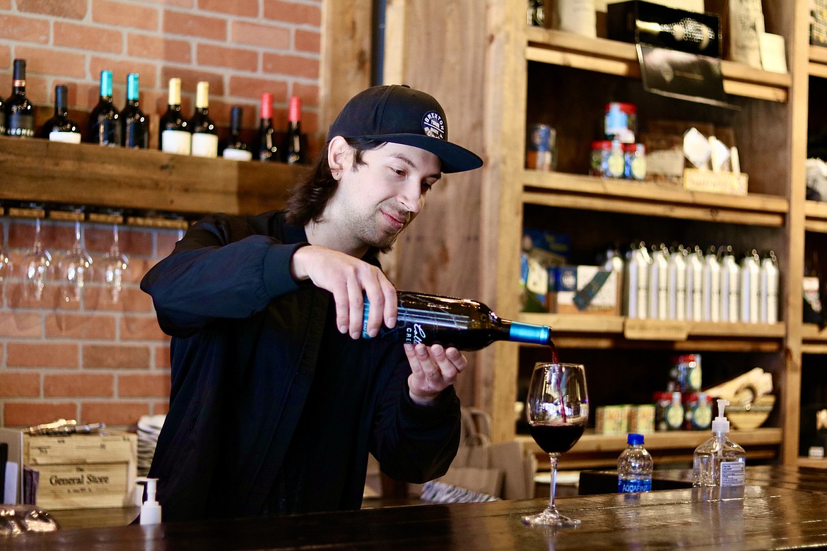 Blake Lopez pours a glass at Coeur d’Alene Fresh Wine Bar in downtown Coeur d'Alene on Thursday. The bar is just one of the 20 shops participating in the Wine Extravaganza wine tasting event on Saturday hosted by the Coeur d'Alene Downtown Association. HANNAH NEFF/Press