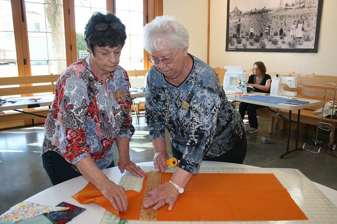Florie Weber (left) helps Sue Simmons Gables (right) cut out a project. People were invited to the Heritage Barn at the Quincy Valley Historical Society and Museum for Community Sew Day the first Monday in April, a chance to work on projects and meet new people.