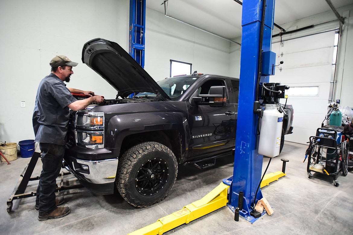 Owner Tom Dalton, an ASE Master Certified Technician, works under the hood of a Chevy Silverado at Dalton's Garage, 128 Spring Creek Drive in Evergreen on Thursday, April 7. (Casey Kreider/Daily Inter Lake)