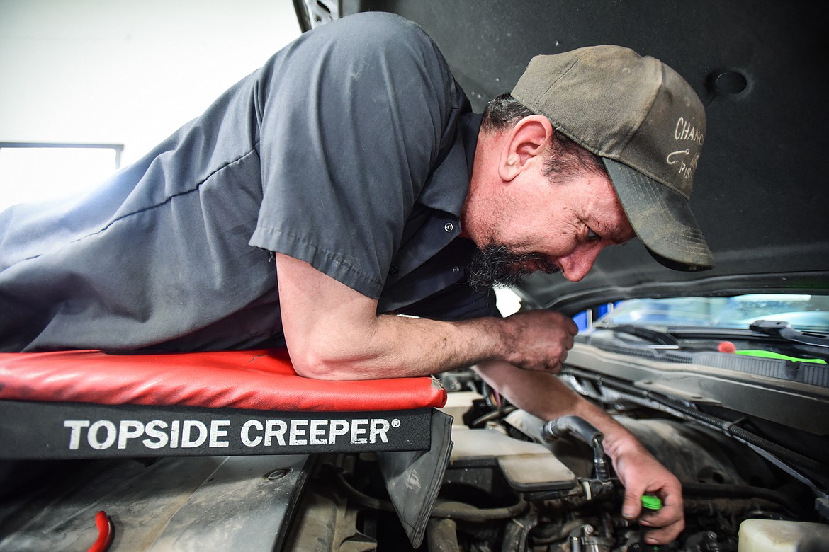 Owner Tom Dalton, an ASE Master Certified Technician, works under the hood of a Chevy Silverado at Dalton's Garage, 128 Spring Creek Drive in Evergreen on Thursday, April 7. (Casey Kreider/Daily Inter Lake)