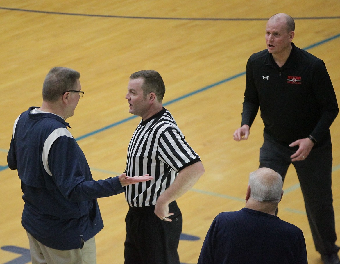 MARK NELKE/Press
Official Tim Young listens to Lake City boys basketball coach Jim Winger while Moscow coach Josh Uhrig, right, looks on.