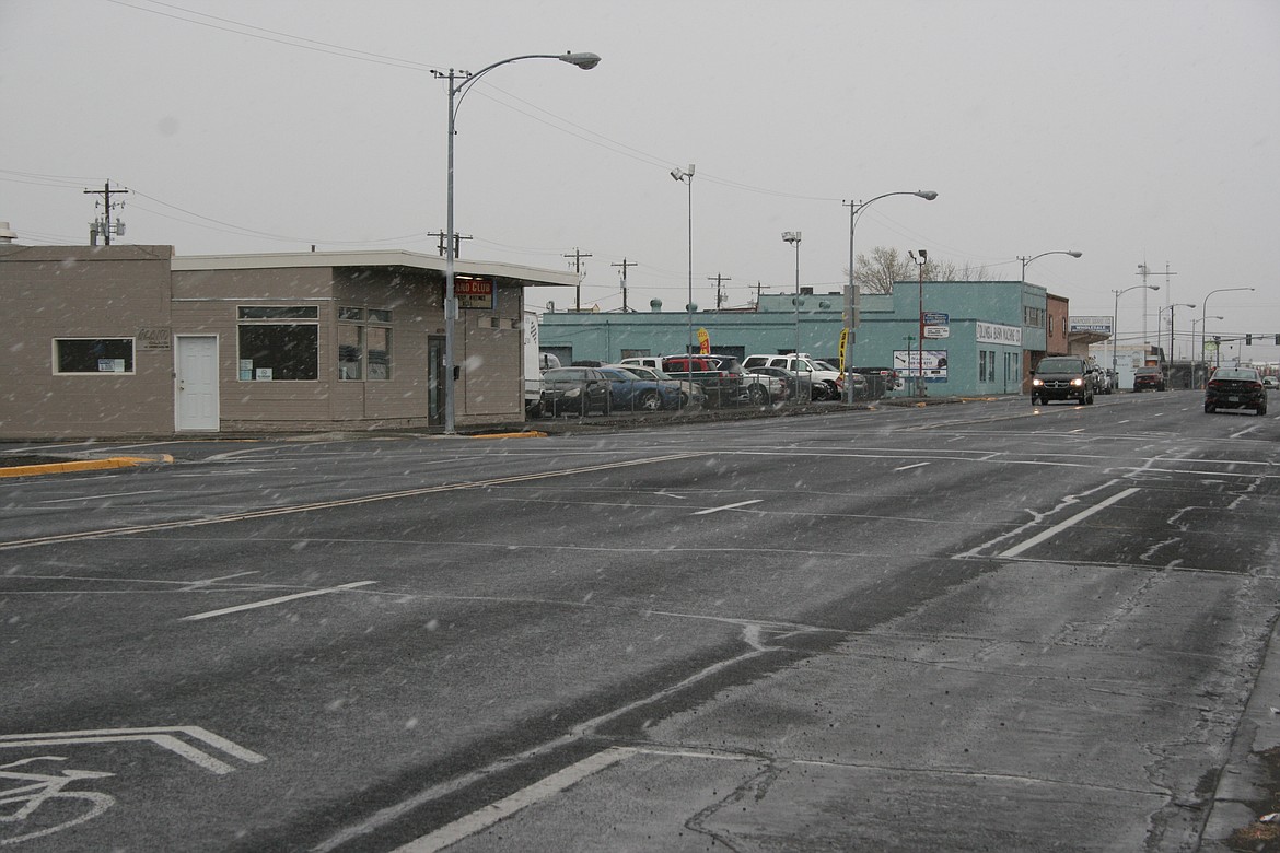 Cars traverse West Third Avenue in Moses Lake during a Monday morning snow flurry. Cold temperatures are forecast to last the entire week.