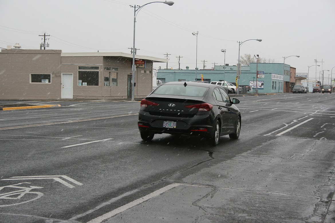 A snow flurry greeted drivers on West Third Avenue in Moses Lake Monday. It’s going to be cold all week, with lows below freezing, according to National Weather Service forecasts.