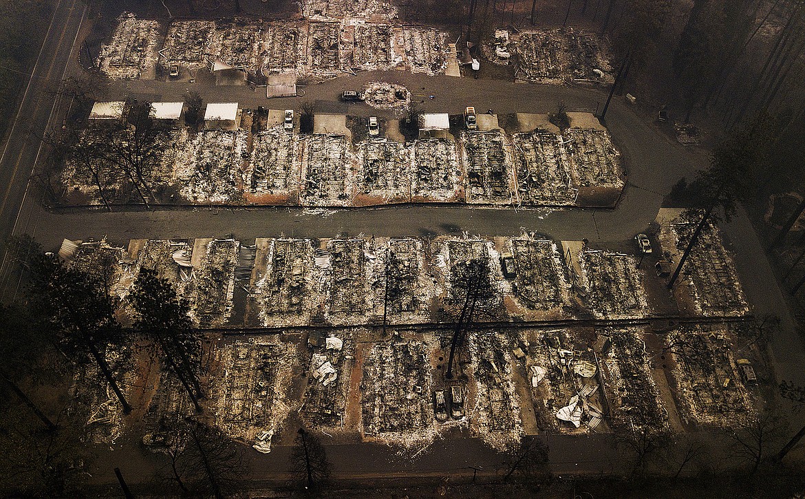 ILE - This Nov. 15, 2018, aerial file photo shows the remains of residences leveled by the Camp wildfire in Paradise, Calif. Pacific Gas & Electric has agreed to pay more than $55 million to avoid criminal prosecution for two major wildfires started by its aging equipment in 2019 and 2021, prosecutors announced. (AP Photo/Noah Berger, File)