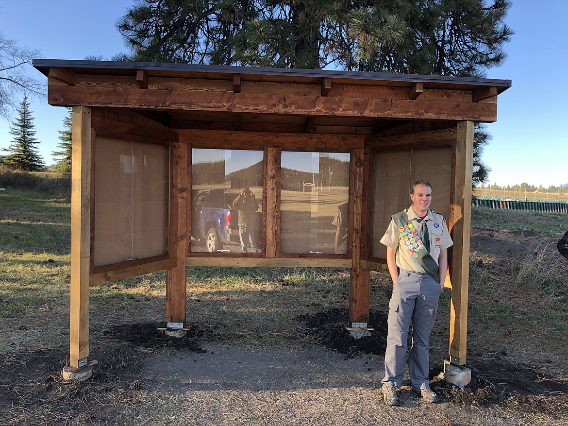 Mark Whitney, a member of BigforkTroop 1923, stands beside his Eagle Scout project, a community board he made for the Lone Pine Cemetery in Bigfork.