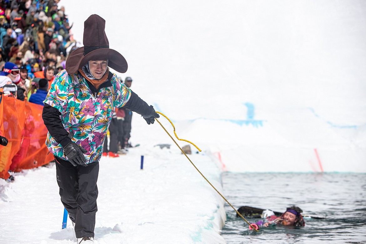 A worker pulls a cold snowboarder to shore. (JP Edge photo)