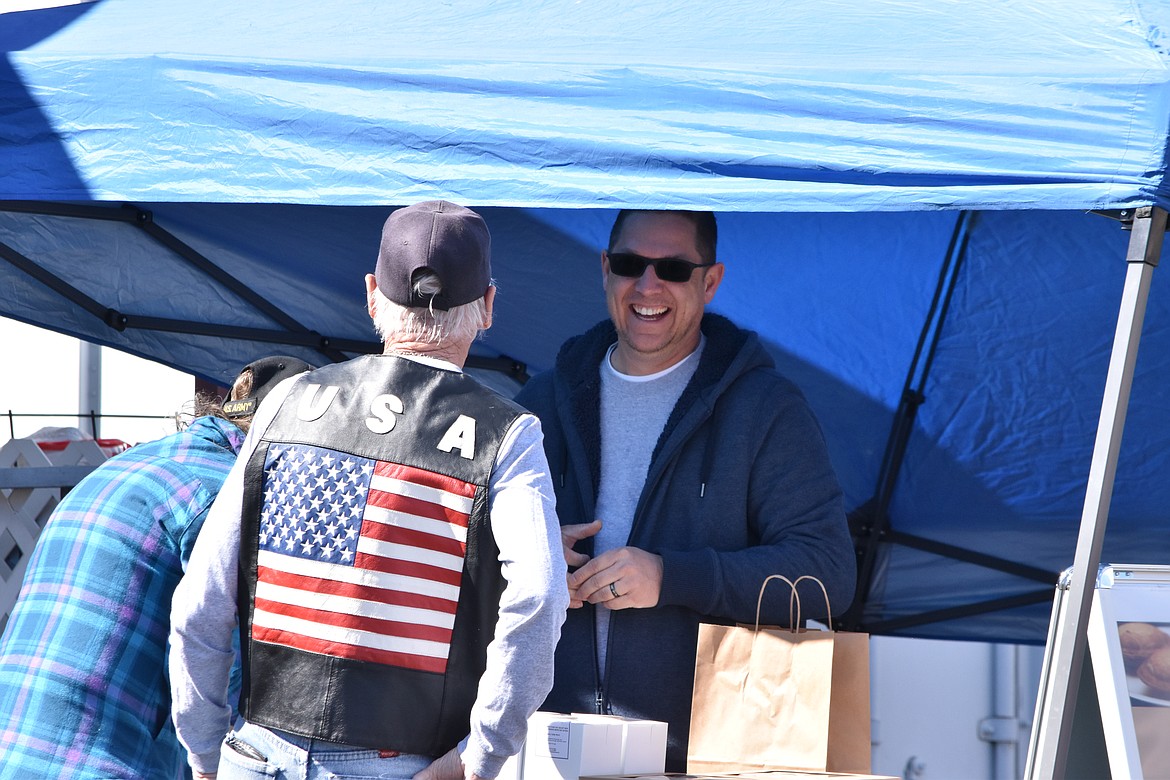 Will Britt, co-owner of Southern Roots Bakery based out of Moses Lake (right) speaks to Frank Grens (middle) and Rosetta Barnes (left) at the Ephrata American Legion Post 28 swap meet and vendor market on April 9. Grens and Barnes are residents of Ephrata.