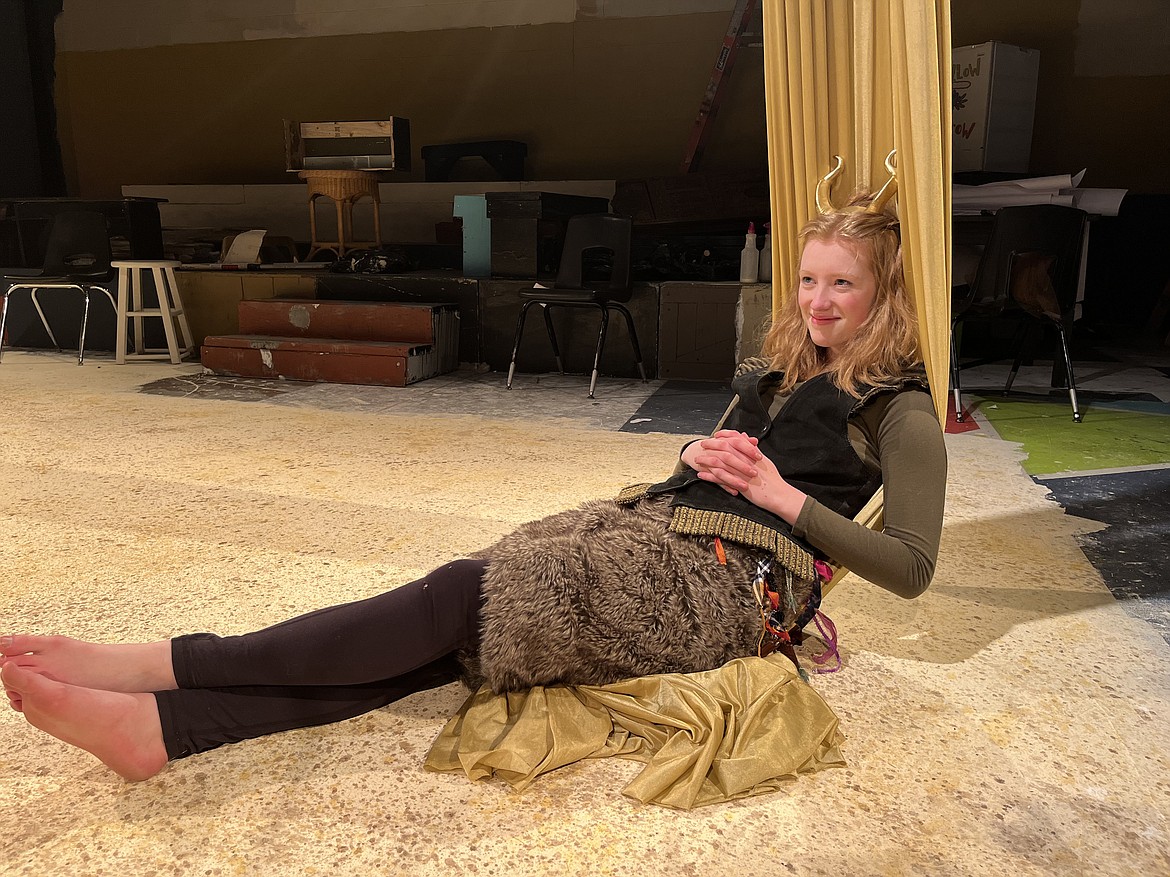 Puck, played by Kadence Johnson, sits reclined, in Flathead High School Theatre’s production of “A Midsummer NIght’s Dream.”