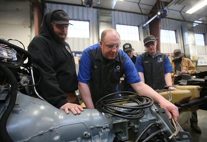 Kootenai Technical Education Campus auto instructor TJ Robertson works with student Jesse Stocker, left, on a 1987 Humvee.