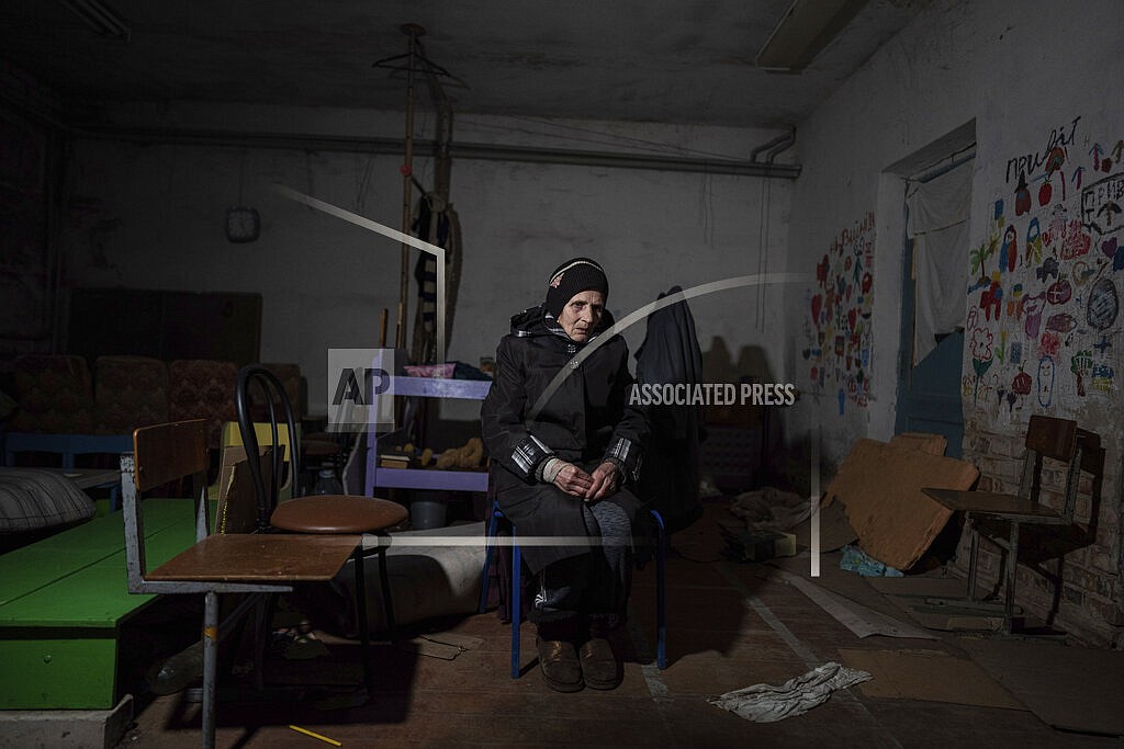 Valentina Saroyan sits in the basement of a school in Yahidne, near Chernihiv, Ukraine, Tuesday, April 12, 2022. Residents say more than 300 people were trapped for weeks by Russian occupiers in the basement of the school in Yahidne. (AP Photo/Evgeniy Maloletka)