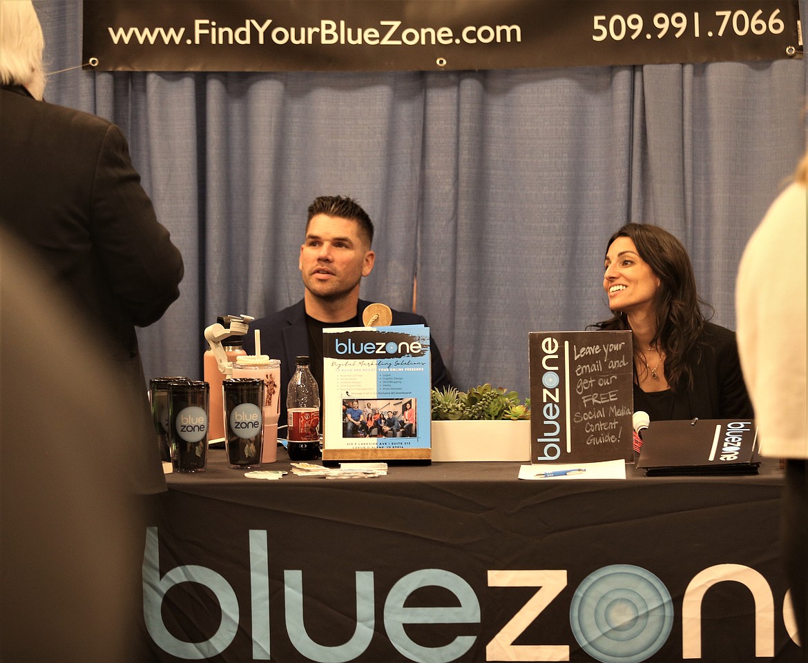 Dominic Longo and Tiffany Longo of Blue Zone Marketing talk to a visitor at the Regional Business Fair at The Coeur d'Alene Resort on Wednesday.