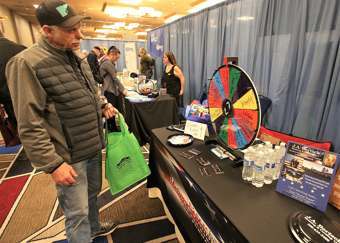 Ron Jones of Post Falls watches the wheel spin at the J.A. Bertsch Heating and Cooling booth at the Regional Business Fair at The Coeur d'Alene Resort on Wednesday.