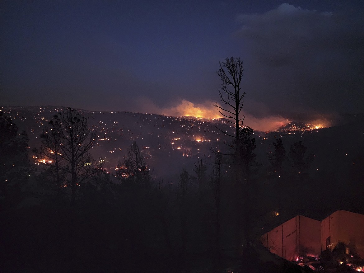 Fire burns along a hillside in the Village of Ruidoso, N.M., on Wednesday, April 13, 2022. Officials say a wildfire has burned about 150 structures, including homes, in the New Mexico town of Ruidoso. (Alexander Meditz via AP)