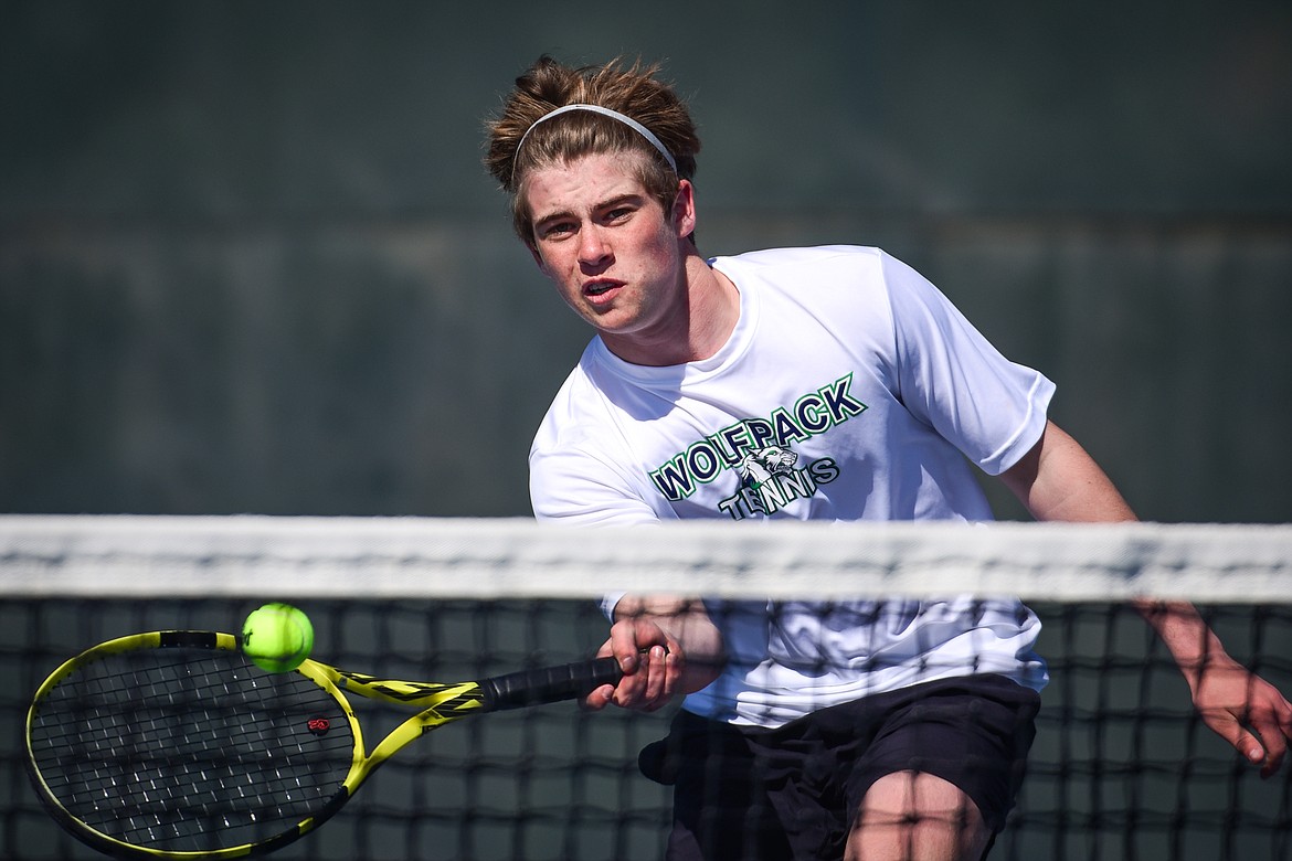 Glacier's Harrison Sanders charges the net to hit a return against Flathead's Quaid Ring at Flathead Valley Community College on Thursday, April 14. (Casey Kreider/Daily Inter Lake)