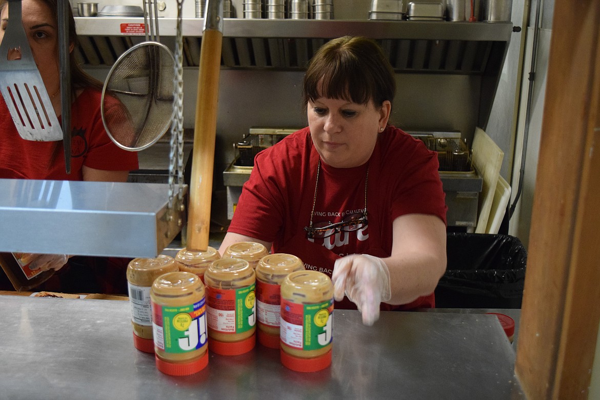 Care Moses Lake organizer and volunteer Michaelle Boetger stacks empty jars of peanut butter, all used up to make sandwiches for the homeless.