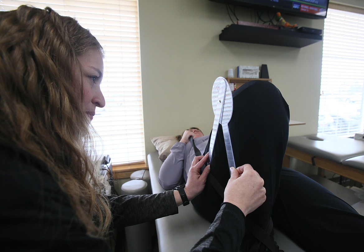 Stephanie Morrison uses a goniometer to take range of motion measurements on Margie Dennis' knee, which recently underwent a partial replacement.