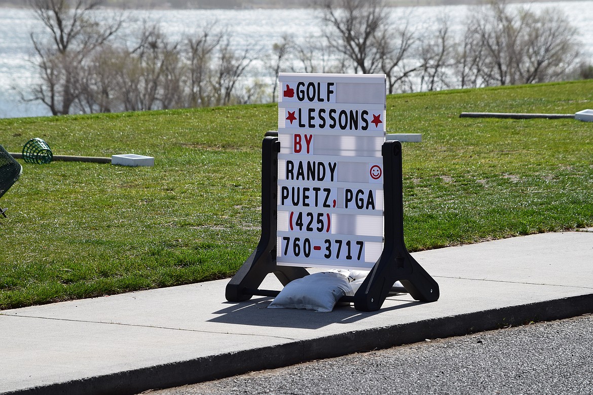 A sign advertising Randy Puetz’s services in front of the driving range belonging to The Links at Moses Pointe.