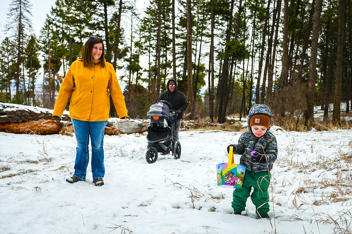 A family walks along a trail scooping up eggs during an Easter egg hunt at Lone Pine State Park in Kalispell on Saturday, April 16. (Casey Kreider/Daily Inter Lake)