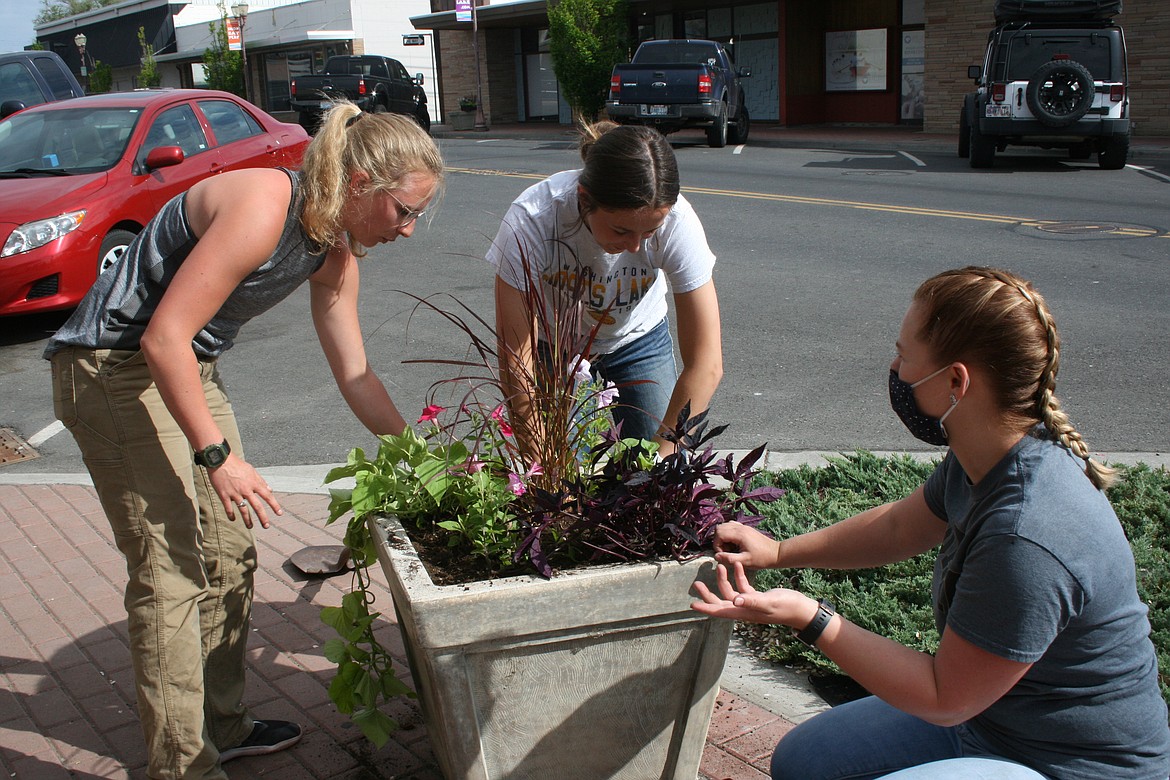 Moses Lake High School students plant flowers in downtown flower pots in May 2021. People can donate to the Adopt a Pot program by contacting the Downtown Moses Lake Association.