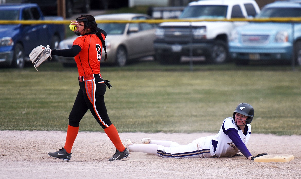 Polson's Carli Maley looks up after sliding safely back to second, beating the tag from Ronan's Kaleigh Benson (8). (Scot Heisel/Lake County Leader)