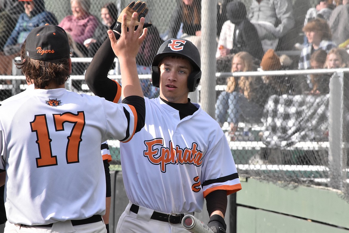 Ephrata High School senior Ethan Gustafson (17) gives a high five to senior Tyson Laugen (2) as he comes in from home base to the dugout. The Tigers are doing well this season according to coach Jason Laugen, who added that the team is focused on game fundamentals.