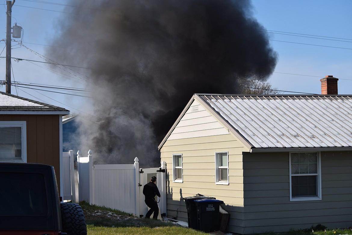 Smoke billows from a shed fire in the backyard of a home in the 300 block of W. Loop Drive as Moses Lake Fire Department firefighters arrive on scene Friday around 8:45 a.m.