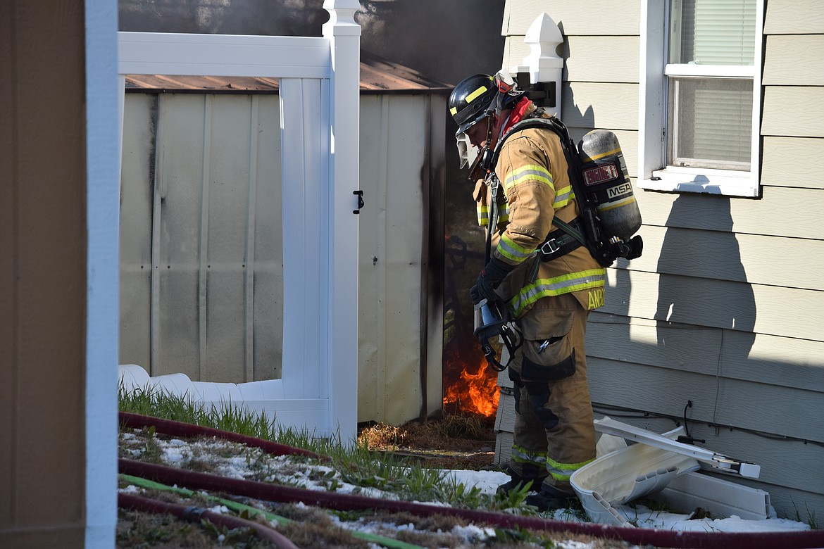 A Moses Lake Fire Department firefighter gets ready to battle a blaze engulfing a backyard shed in the 300 block of W. Loop Drive Friday morning. No one was injured in the fire and no permanent structures were damaged in the blaze that gutted the shed.